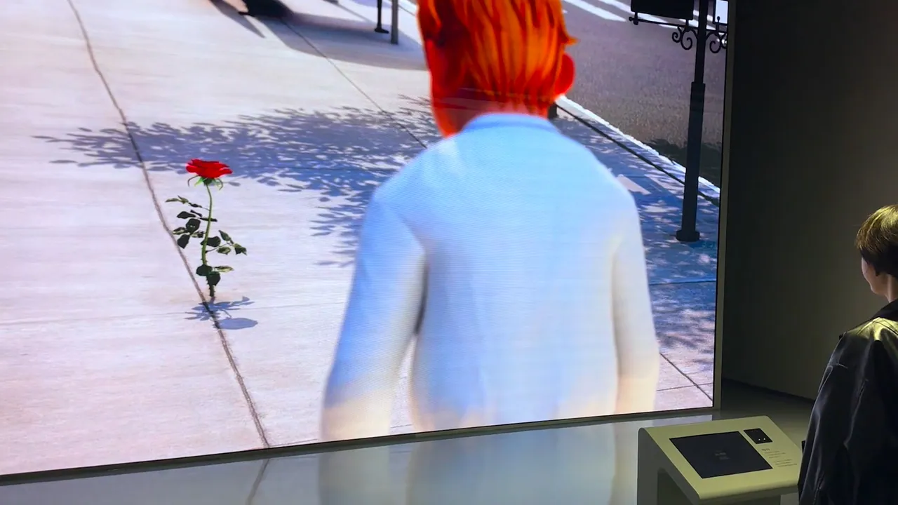LED wall showing the office-worker character from behind, stopped on a city pavement beside a single red rose growing through the paving, with a visitor at a kiosk